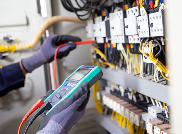 An electrician testing a fuseboard